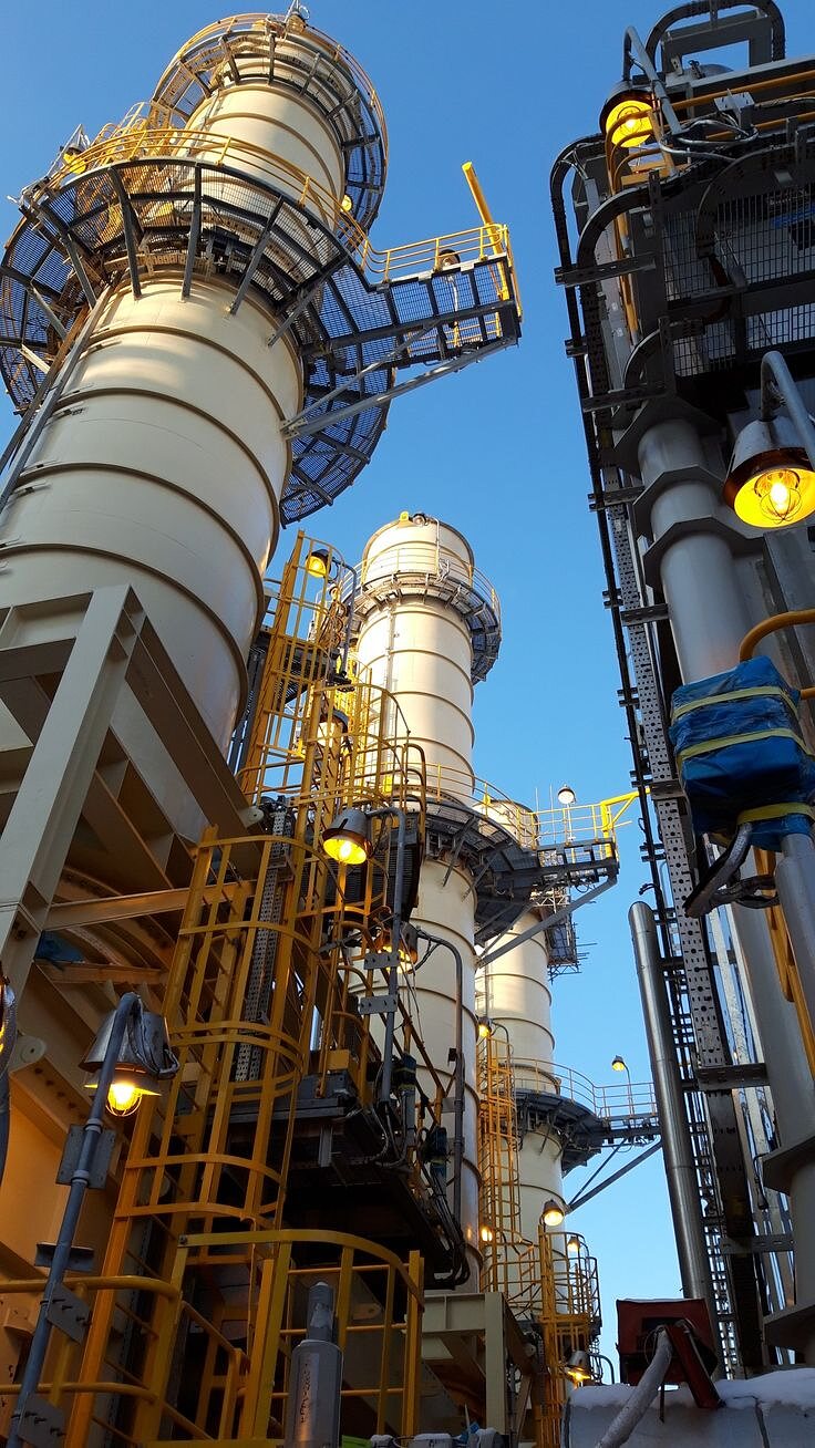 Power plant exhaust stacks and access stairways under a clear sky